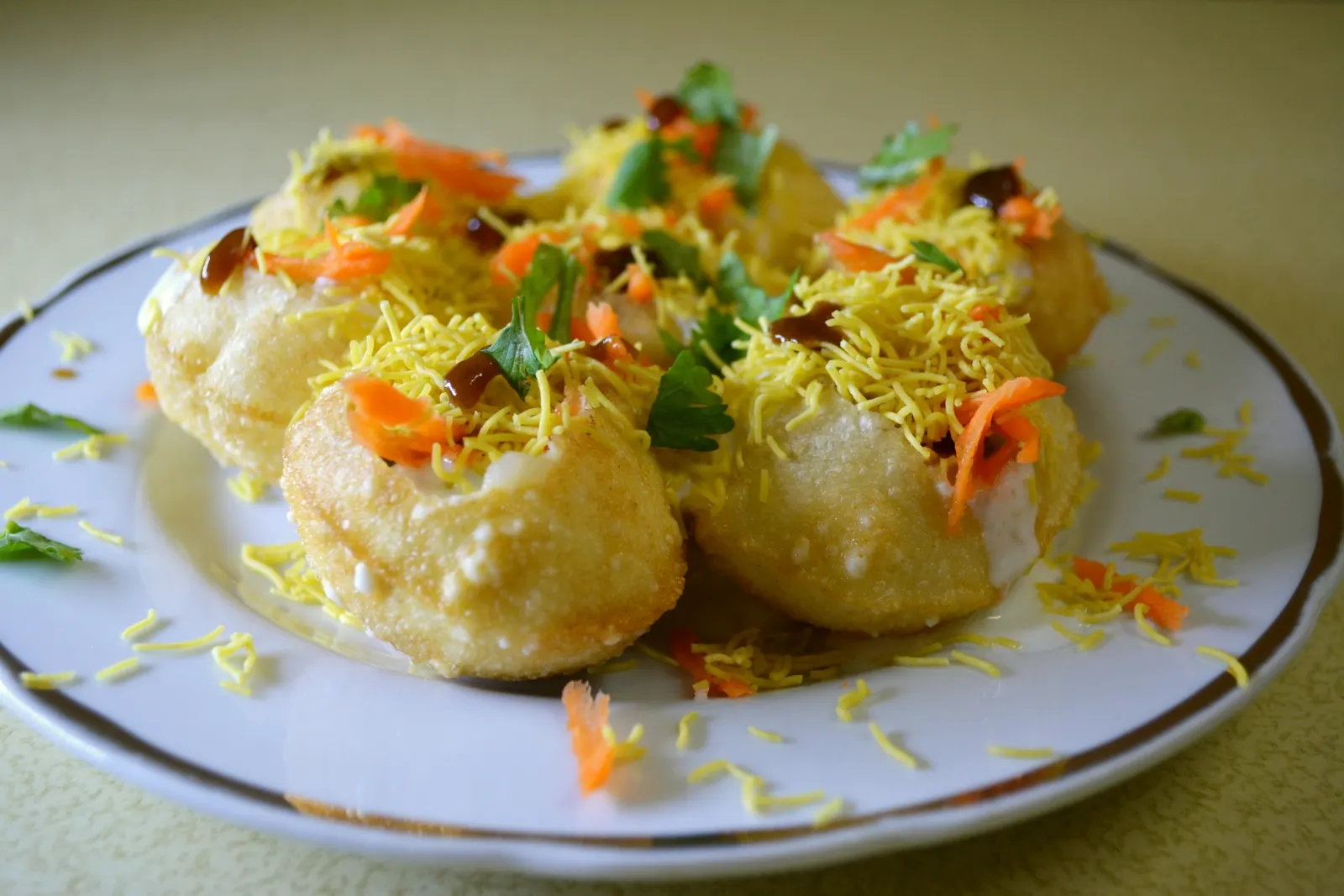 A street food vendor assembling plates of Indian chaat at a busy roadside stall