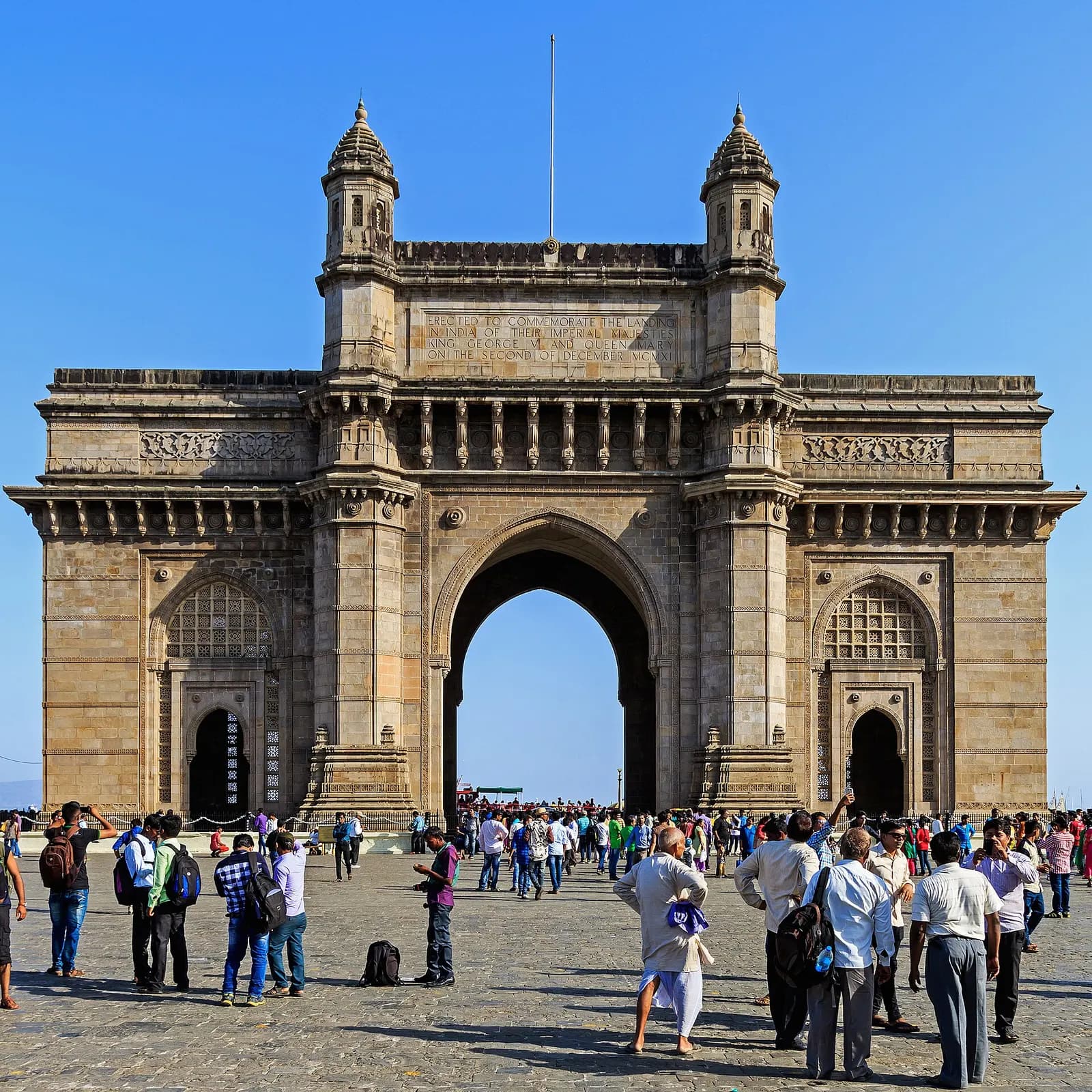 The Gateway of India arch on the Mumbai waterfront with boats in the harbour behind it