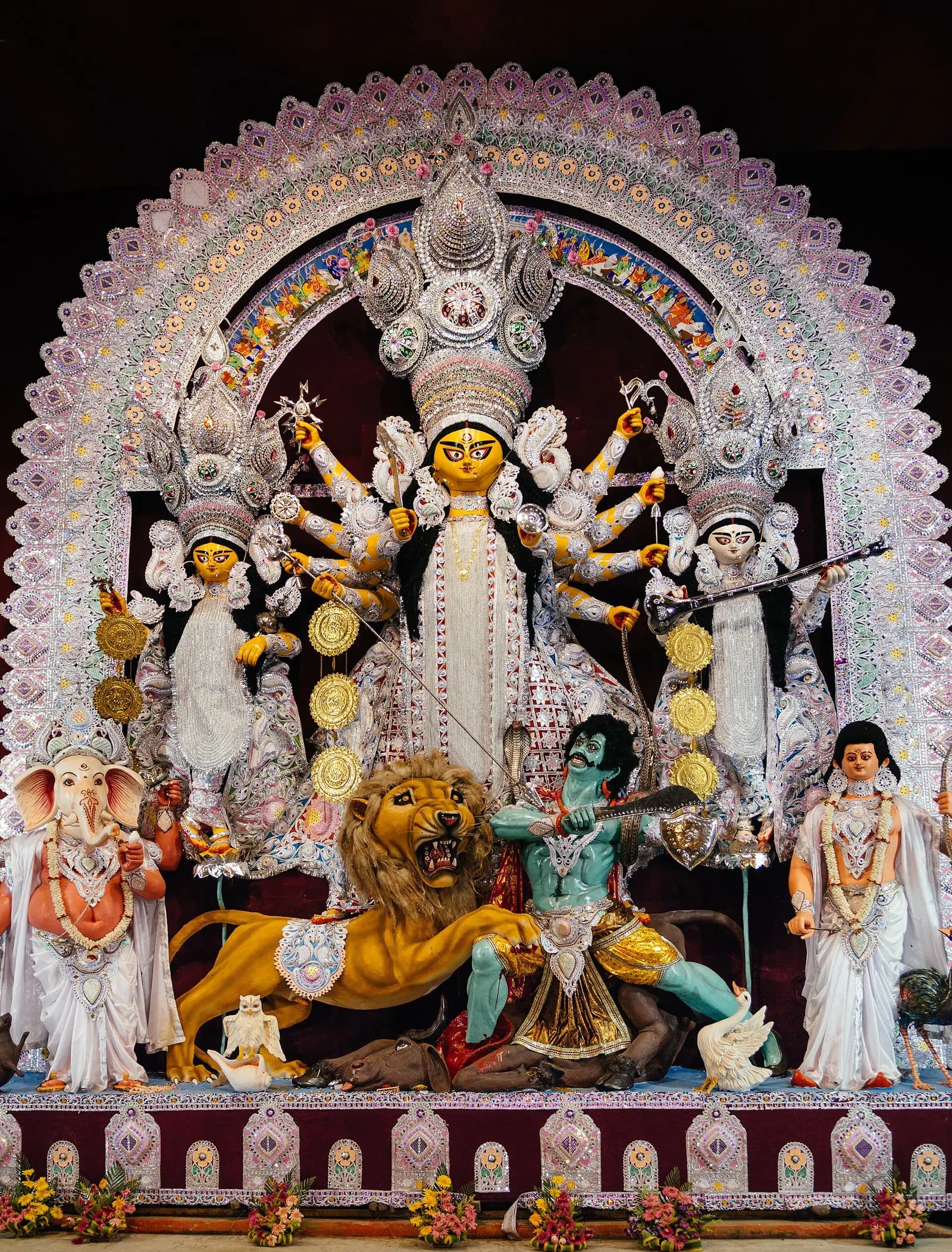 A clay Durga idol installed in a lit Kolkata pandal during Durga Puja
